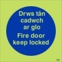Glow in the dark bilingual fire door keep locked safety sign in Welsh and English