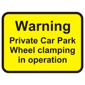 Warning private car park wheel clamping in operation sign with bold black text on yellow background