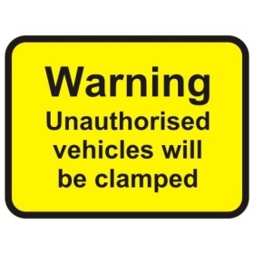 Warning unauthorised vehicles will be clamped sign with bold black text on yellow background
